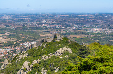 Fototapeta na wymiar Panoramic aerial view from the Pena Palace of the Arab castle, built by the Moors, taken by the Vikings and conquered by the King of Portugal. In Sintra, Portugal. Castelo dos Mouros