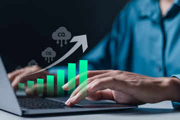 Businessman use laptop with growth graph of CO2 reducing. Climate change to limit global warming and sustainable development and green business concept.