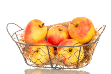 Several yellow apples in a basket, macro, isolated on a white background.