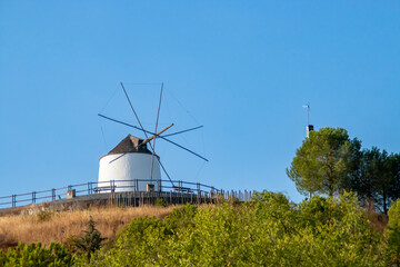 Molino de viento tradicional en lo alto de una colina en un día despejado en Sanlúcar de...