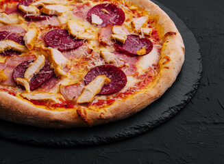 Pepperoni Pizza with Basil and Parmesan Cheese on Black Stone Plate