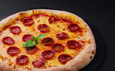Pepperoni Pizza with Basil and Parmesan Cheese on Black Stone Plate