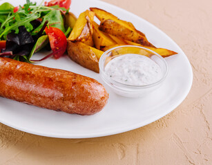 Roasted sausages with baked potatoes and green salad