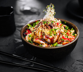 Salad with eel and couscous on black bowl