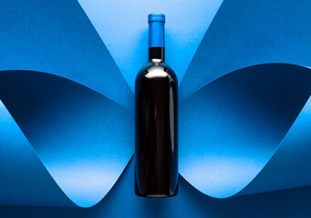 Bottle of red wine on a blue background.