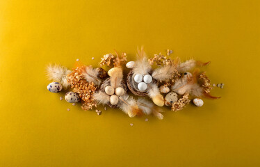 Easter composition with quail eggs, feathers, and dried flowers.