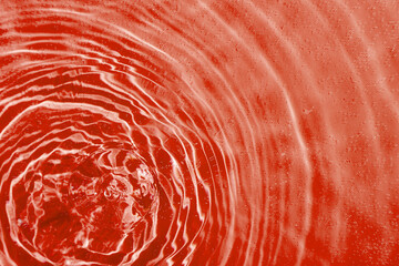 drops on water with circles on a red background