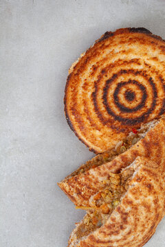 Jaffle, an old school toasted sandwich, filled with savory mince. Grey backdrop, copy space