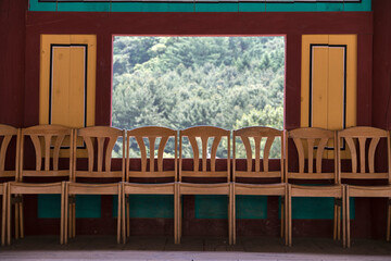 View of the chairs against the wall and mountain in the Buddhist temple building