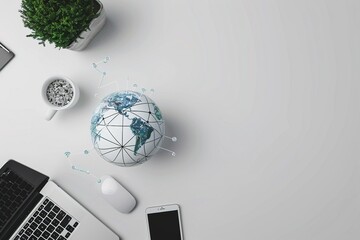 A laptop, mouse, and cell phone are on a table with a globe and a potted plant