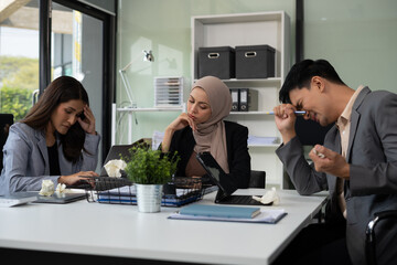 Teamwork, people and crisis concept - business team sitting sad and solving problems in the office.