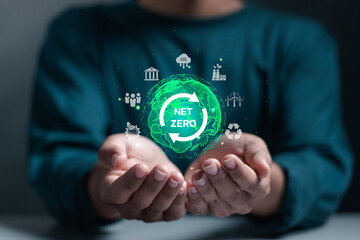 Net zero and carbon neutral concept. Businessman holding globe with net zero icon on virtual screen for net zero greenhouse gas emissions target and climate neutral long term strategy.