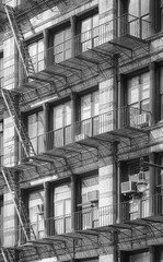 Black and white photo of an old building with fire escape, New York City, USA. - 753535401
