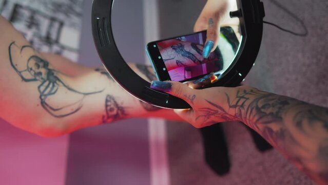 Professional tattoo artist takes pictures of her client tattoos using ring light. High quality 4k footage