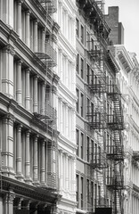 Black and white photo of old buildings with fire escape, New York City, USA.