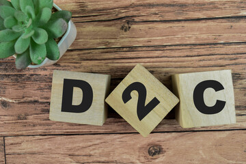 Concept of The wooden Cubes with the word D2C - Direct to Consumer on wooden background.