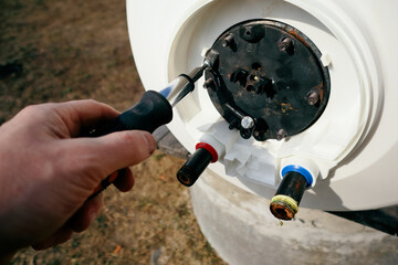 Repair and maintenance of storage water heater. A plumber unscrews the boiler flange. Plumbing work.