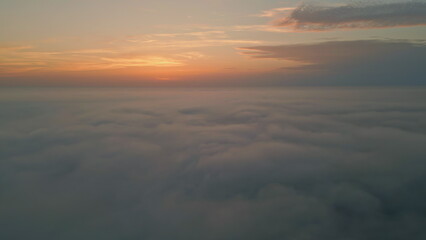 Amazing sunrise fluffy clouds aerial view. Golden horizon at summer morning