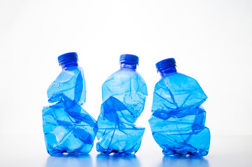 Plastic bottles, blue and transparent, crushed. Waste and plastic pollution, plastic recycling. 
