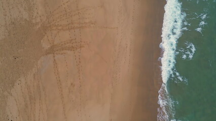 Fototapeta na wymiar Aerial scenic ocean water washing golden sand on empty beach. Waves splashing