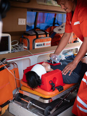 Emergency Care Assistant Putting Non-Invasive Ventilation Mask in an Ambulance car .
