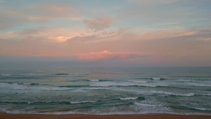 Amazing ocean sunset aerial view. Cinematic sea water washing sandy beach 