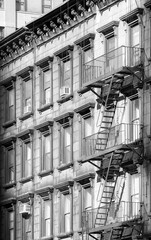 Black and white photo of old building with fire escape, New York City, USA.