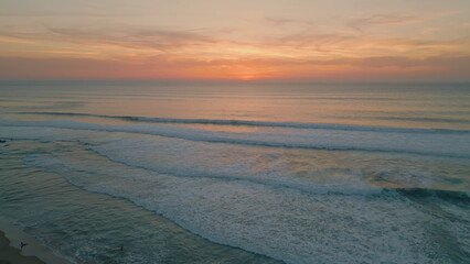 Peaceful ocean evening dusk with golden cloudy sky over endless horizon aerial 