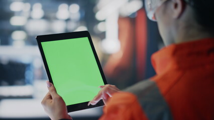 Technician hands touching chroma key tablet on industrial production close up.