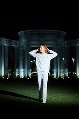 Beautiful young girl in white clothes at night in the park.