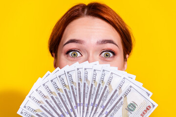 Photo of excited funky woman holding currency fan cover mouth isolated yellow color background