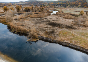 Aerial blue river curve in autumn valley
