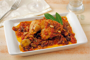 Chicken leg with raisins and pine nuts.