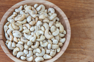 Cashews in a wooden bowl. Nuts are healthy food. Wooden background. Cashew kernel