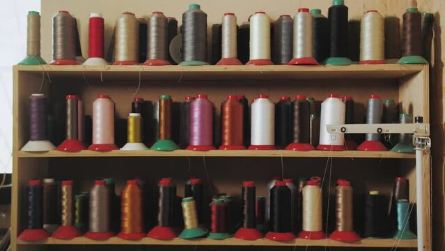 A shelf with colorful spools of thread