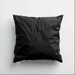A sleek black square pillow is featured prominently against a stark white background. The pillow displays a smooth satin-like material with a subtle sheen, giving it a luxurious appearance. 