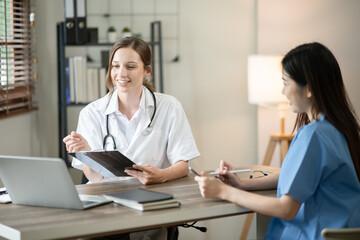 Female doctor sitting at work looking at the history of patients in the clinic or in the hospital