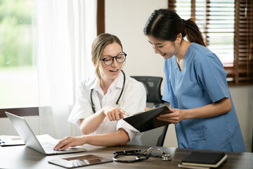 Fototapeta premium Female doctor sitting at work looking at the history of patients in the clinic or in the hospital