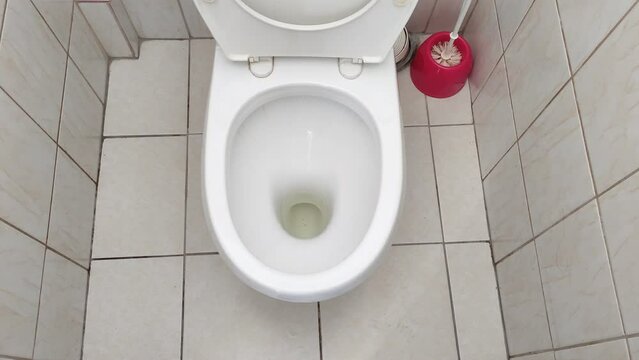 Toilet with urine residue in a tiled bathroom