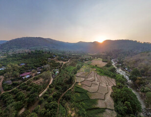 High-angle landscape, rice fields in the middle of mountains with a river flowing through. Cold...