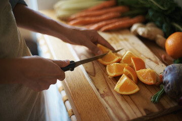 Closeup, kitchen and fruits with hands, orange or wood board with knife, vegetables or salad....