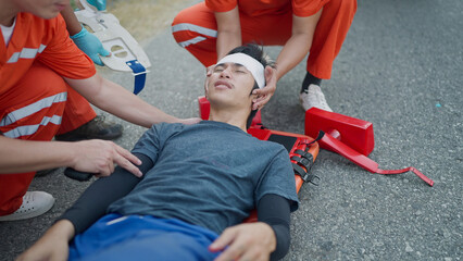 Team rescue helping victims injured in an accident using emergency bed and splinting the neck...