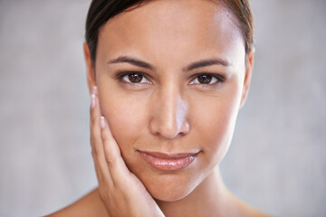 Face, natural beauty and woman with cosmetic care, shine and hand touching skin on grey background....