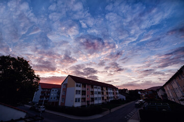 The early morning sky, awash with the soft glow of dawn, provides a beautiful backdrop to a peaceful residential neighborhood