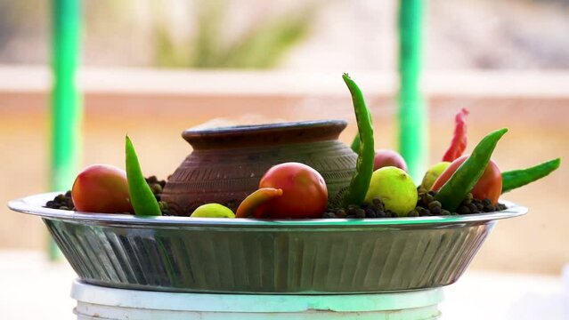 slow motion shot showing smoke coming out from earthenware pot in the middle of lemon, tomato, chillies showing popular street food of bhel puri chat in India