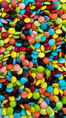 The photo shows multicolored, candy-coated chocolates, useful for baking and decorating, creating a cheerful, colorful concept.