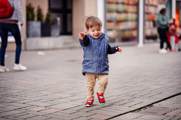A joyful toddler reaches out to the world around him, his face alight with excitement and the...