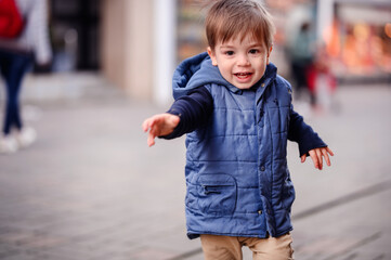 A joyful toddler reaches out to the world around him, his face alight with excitement and the...