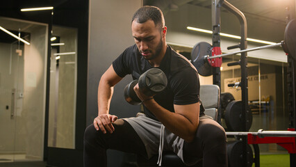African American man lift dumbbell in gym sporty guy sport male trainer bodybuilder athlete workout lifting up hammer curl weight exercise physical muscle training health hard effort arm hand biceps
