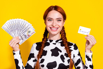 Photo of funky cheerful woman wear cow skin print top comparing cash credit card isolated yellow color background - obrazy, fototapety, plakaty